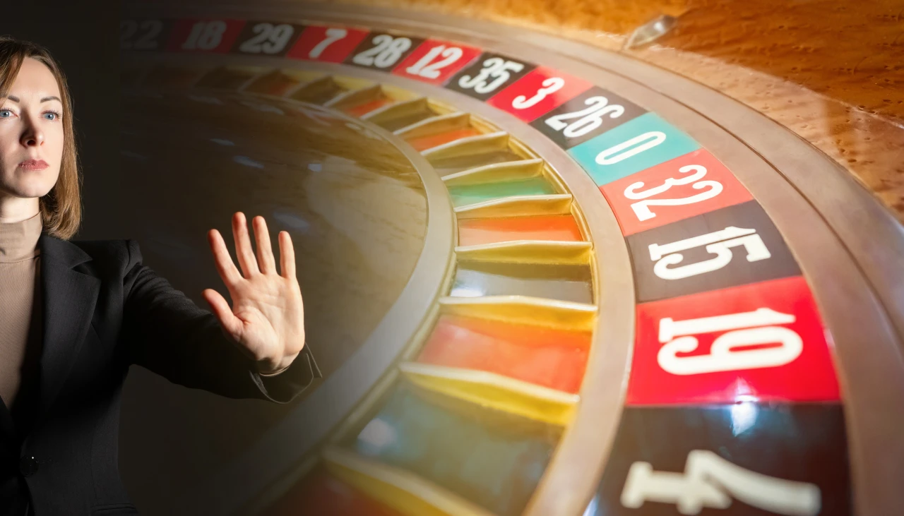 Vrouw bij roulettetafel houdt hand op als teken dat je moet stoppen met gokken.